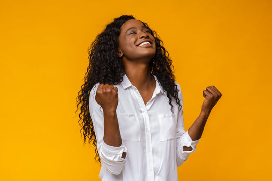 Girl with big smile and fists clenched in celebration